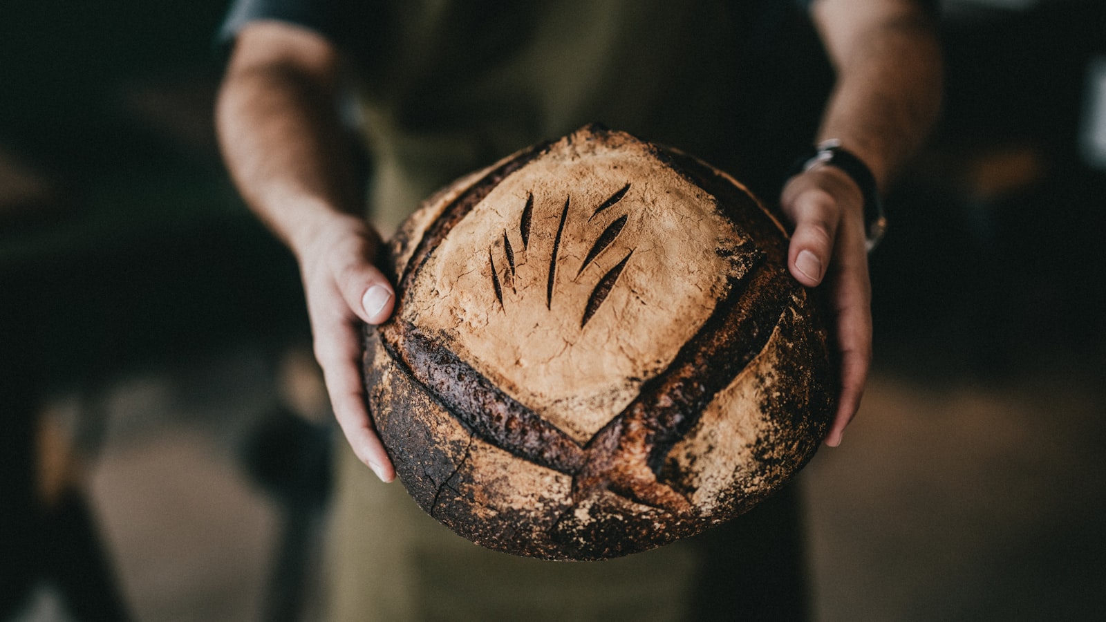 Frisch gebackenes Sauerteigbrot in zwei Händen