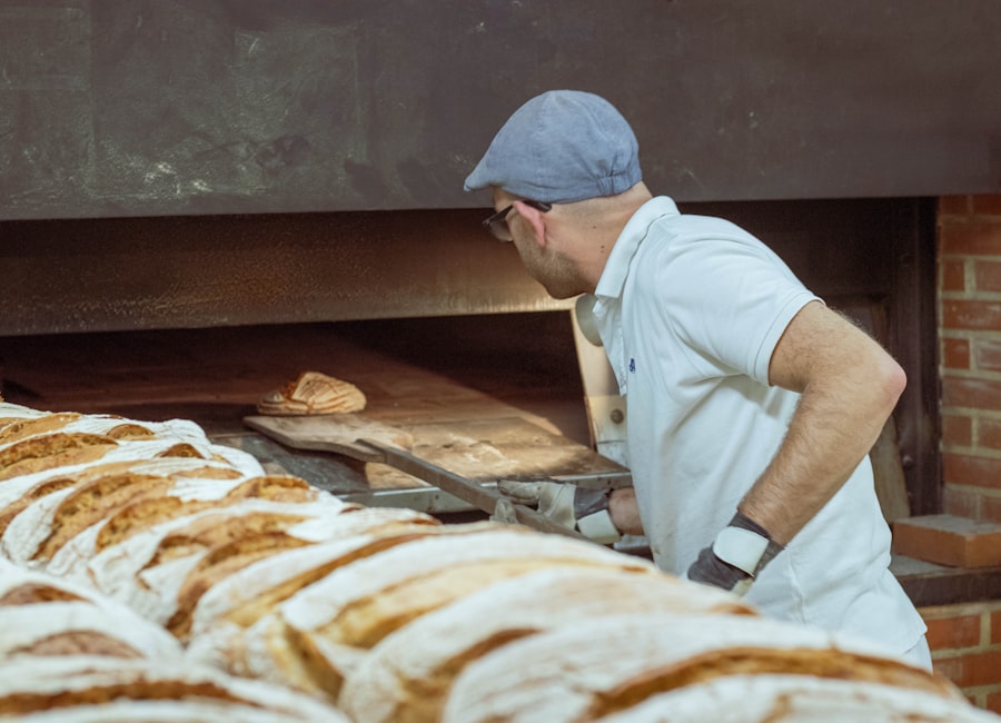 Bäcker schiebt Brotlaibe mit dem Holzschieber in den Steinofen